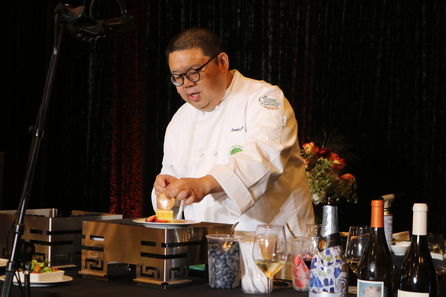 Celebrity chef Dennis Chan of Blue Bamboo Canton Bistro garnishes his award-winning Mandarin orange cake with brittle during his presentation.